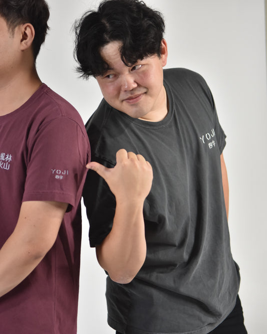 YOJI black shirt, worn by a model next to a friend